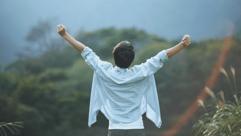 Person Celebrating in Nature with Outstretched Arms. Mountains in the background. Church Equip Curriculum. Love and Unashamed. Romans